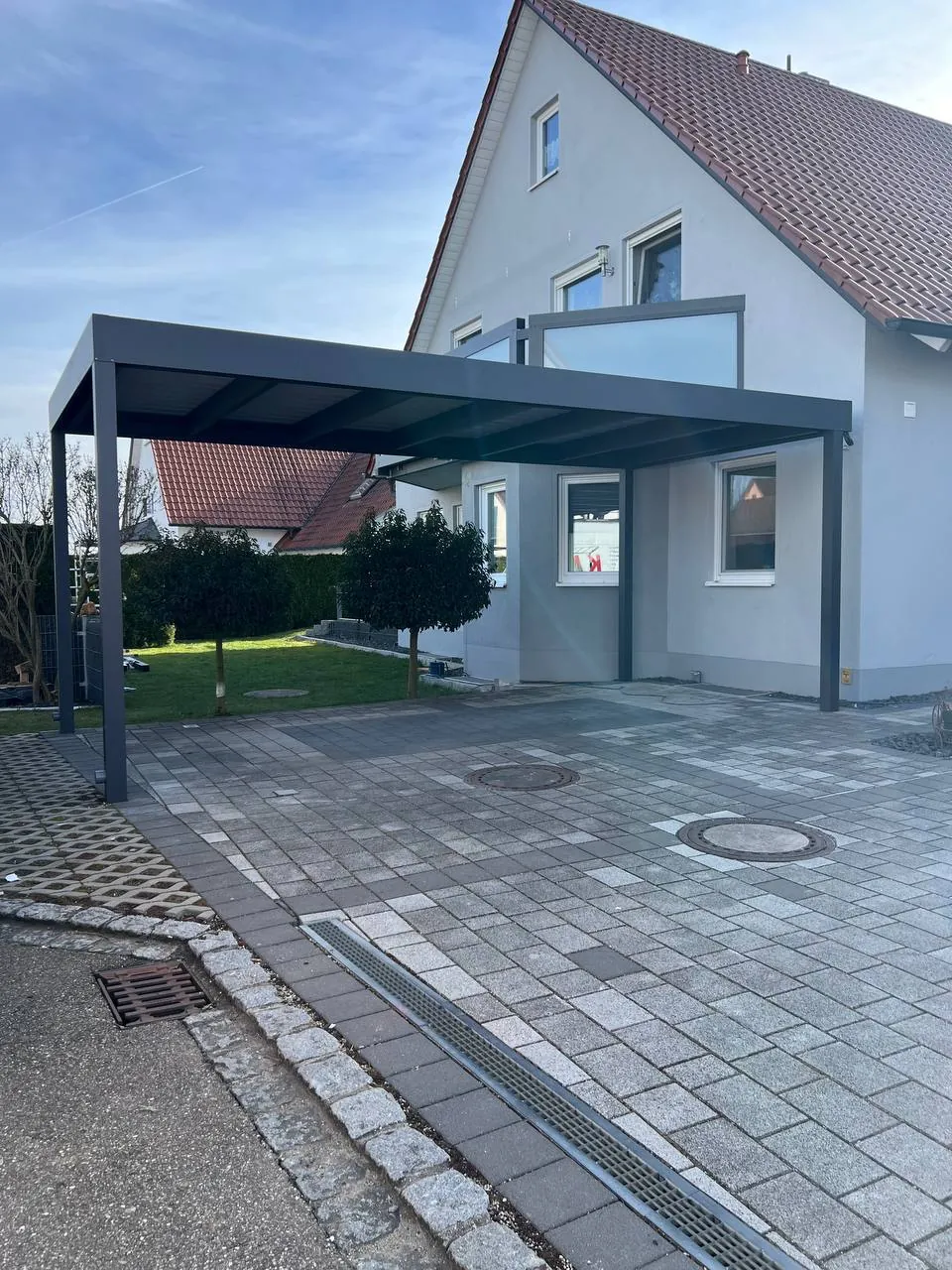 Alu-Carport in Anthrazit vor einem Einfamilienhaus