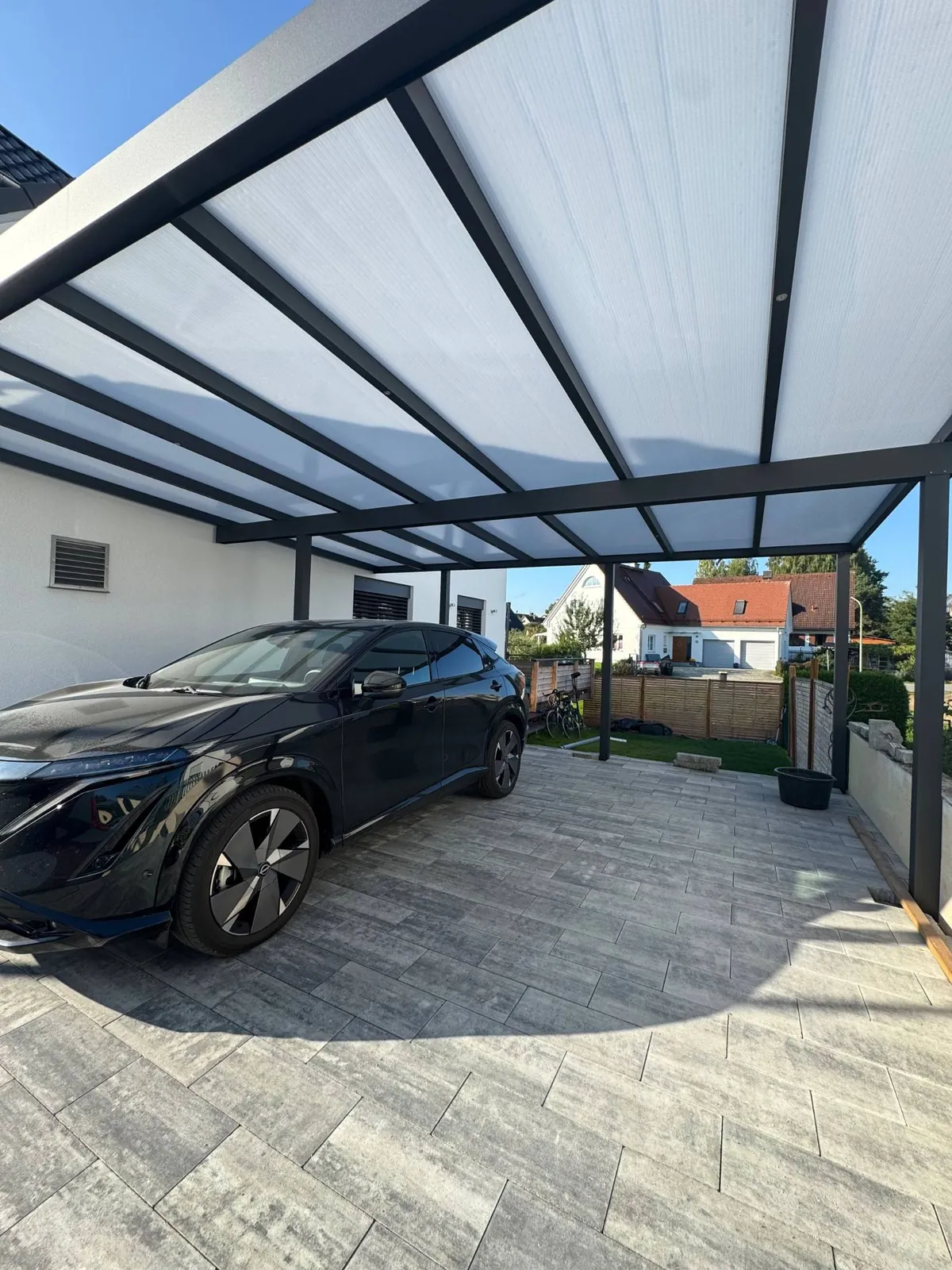 Carport mit lichtdurchlässigem Dach und Fahrzeug