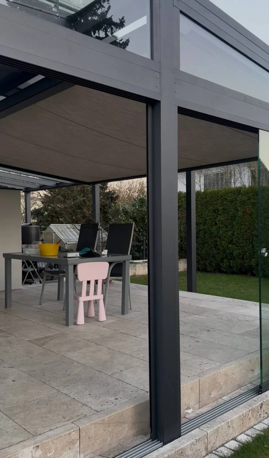 Unterglasmarkise mit Holzoptik-Gewebe über einer überdachten Terrasse