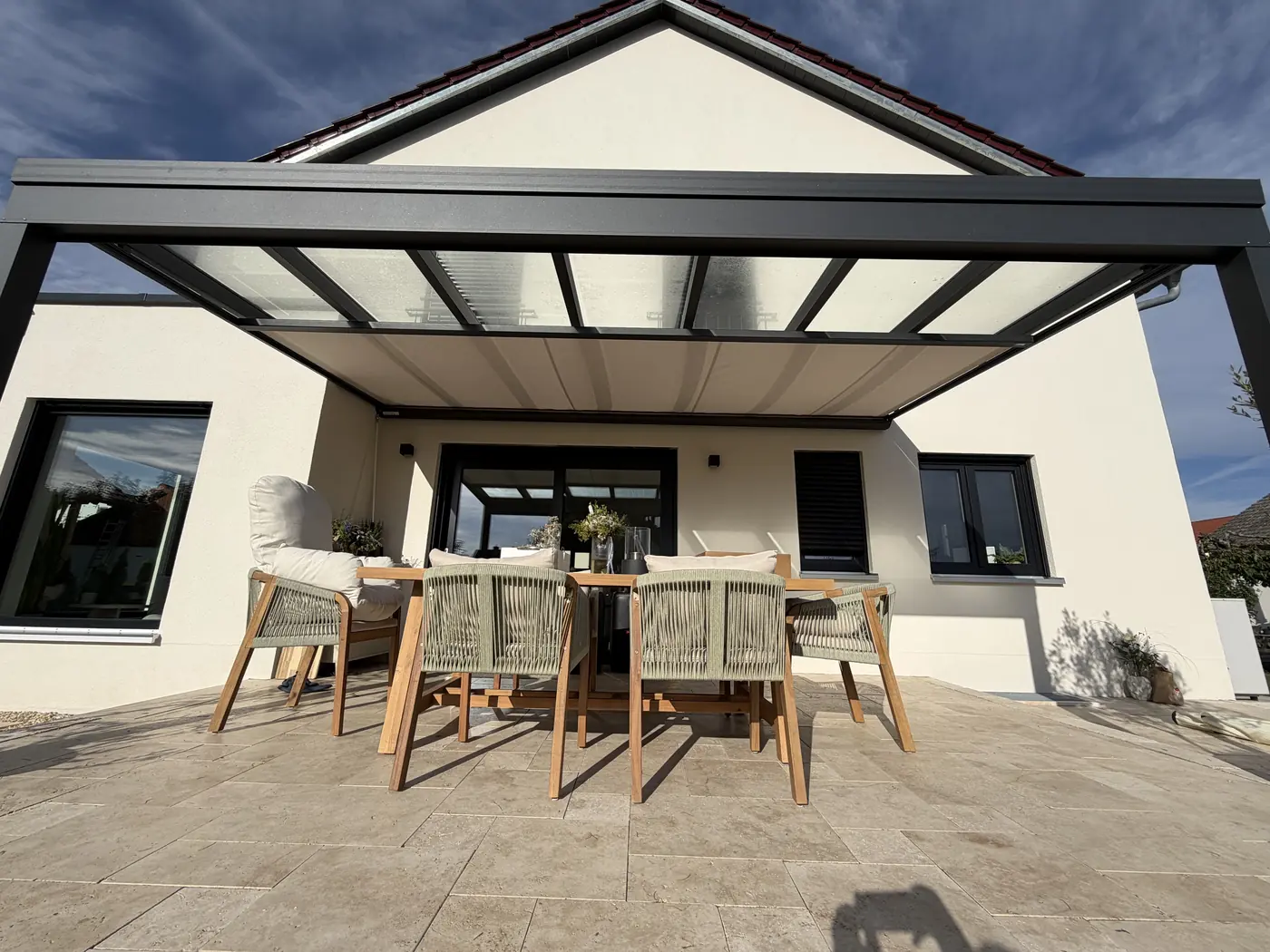 Terrassenüberdachung mit Glasdach und Sitzgruppe