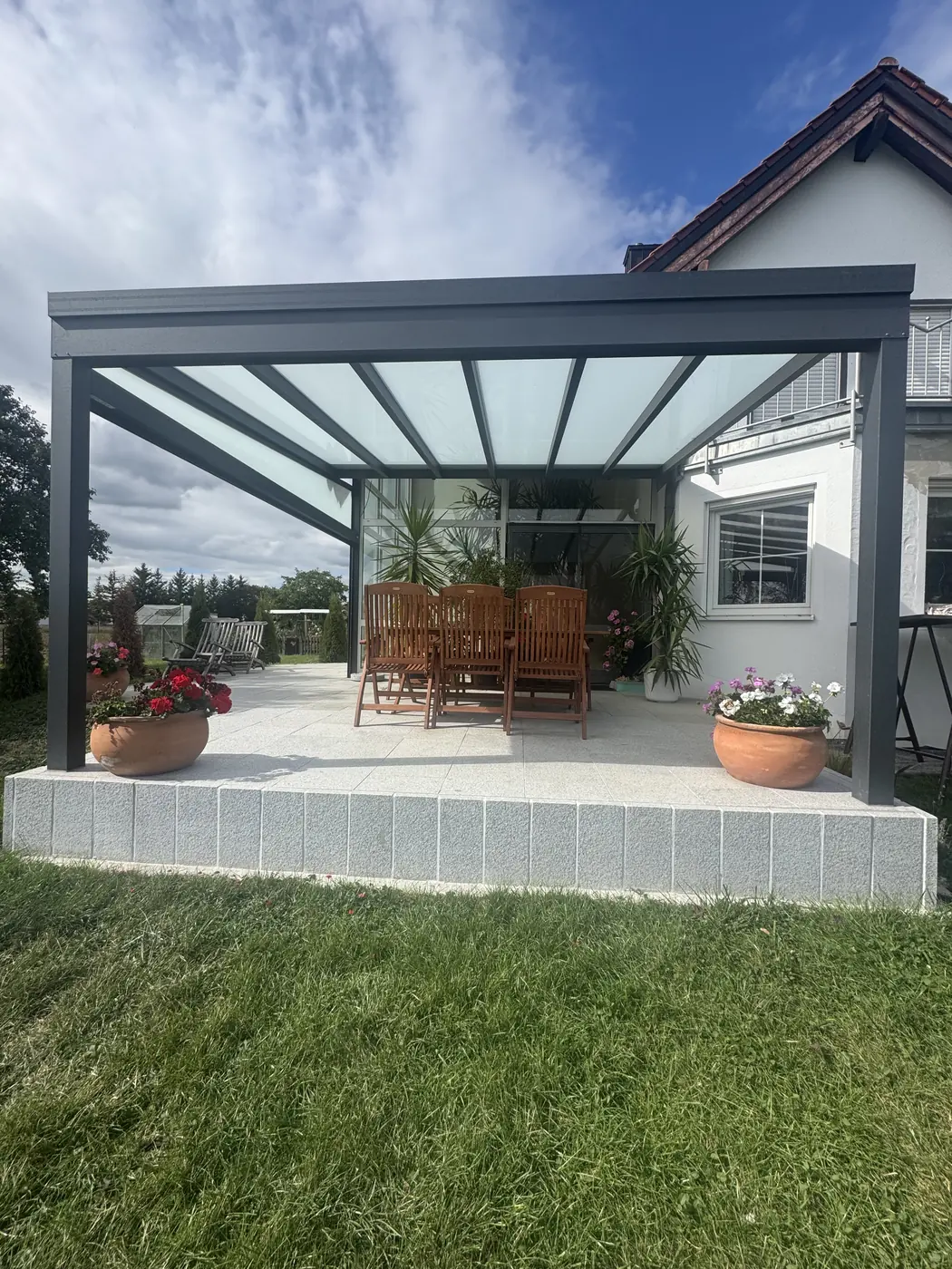 Terrassenüberdachung mit Glasdach über Granitterrasse