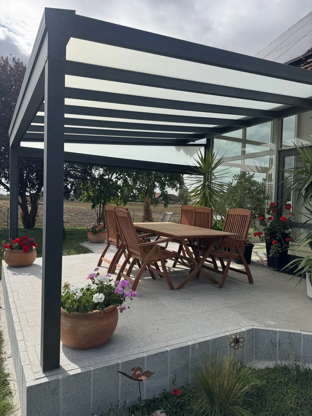 Terrassenüberdachung mit Glasdach und Essbereich