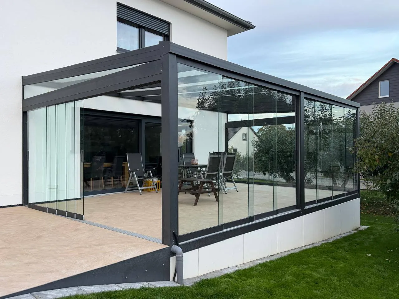Wintergarten mit Glasschiebewänden und Alu-Rahmen in Anthrazit an einem Wohnhaus