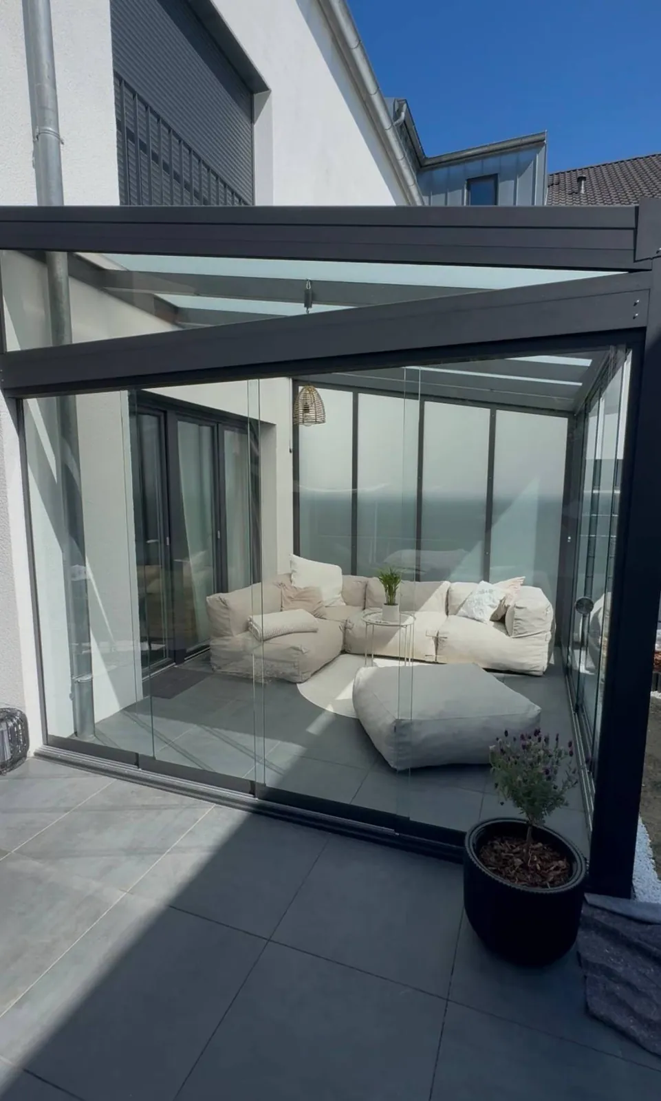 Wintergarten mit Glasschiebewänden als gemütlicher Loungebereich