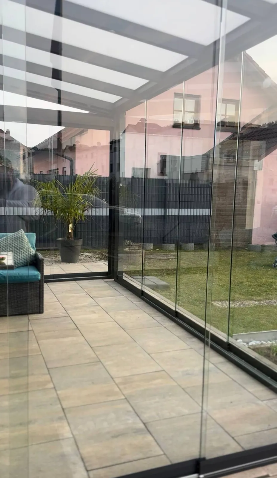 Wintergarten mit Glasschiebewänden und Sitzbereich